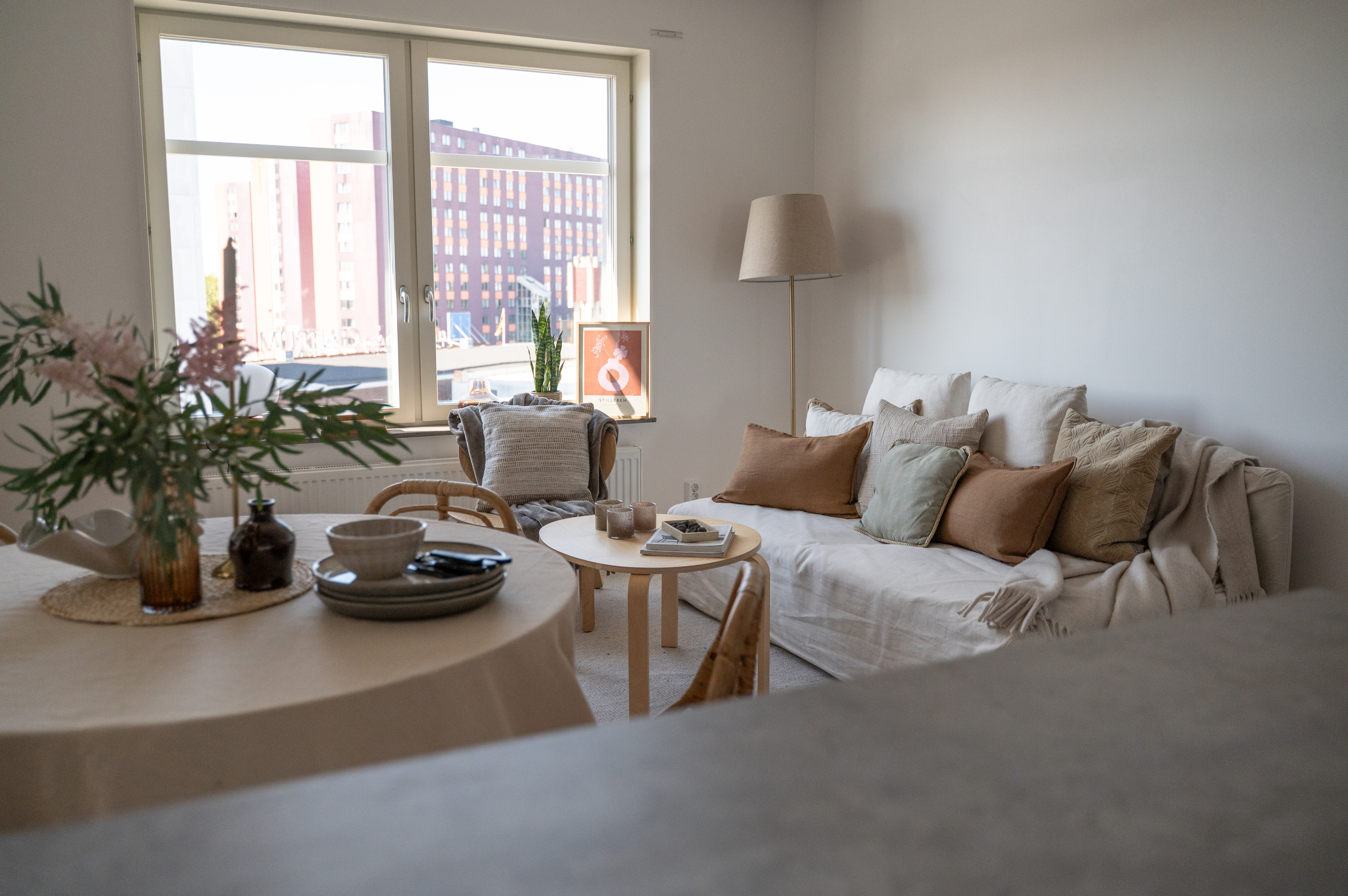 Ett vardagsrum fyllt med möbler och ett stort fönster.